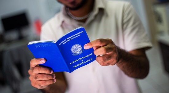 Homem segurando carteira de trabalho