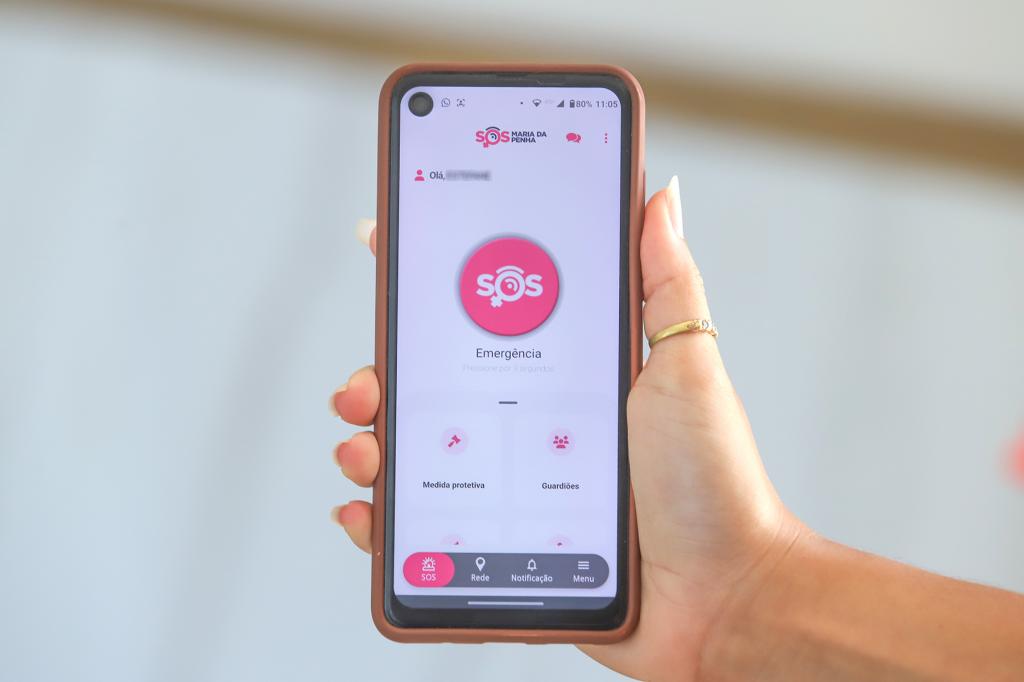 Celular mostrando na tela o aplicativo SOS Maria da Penha