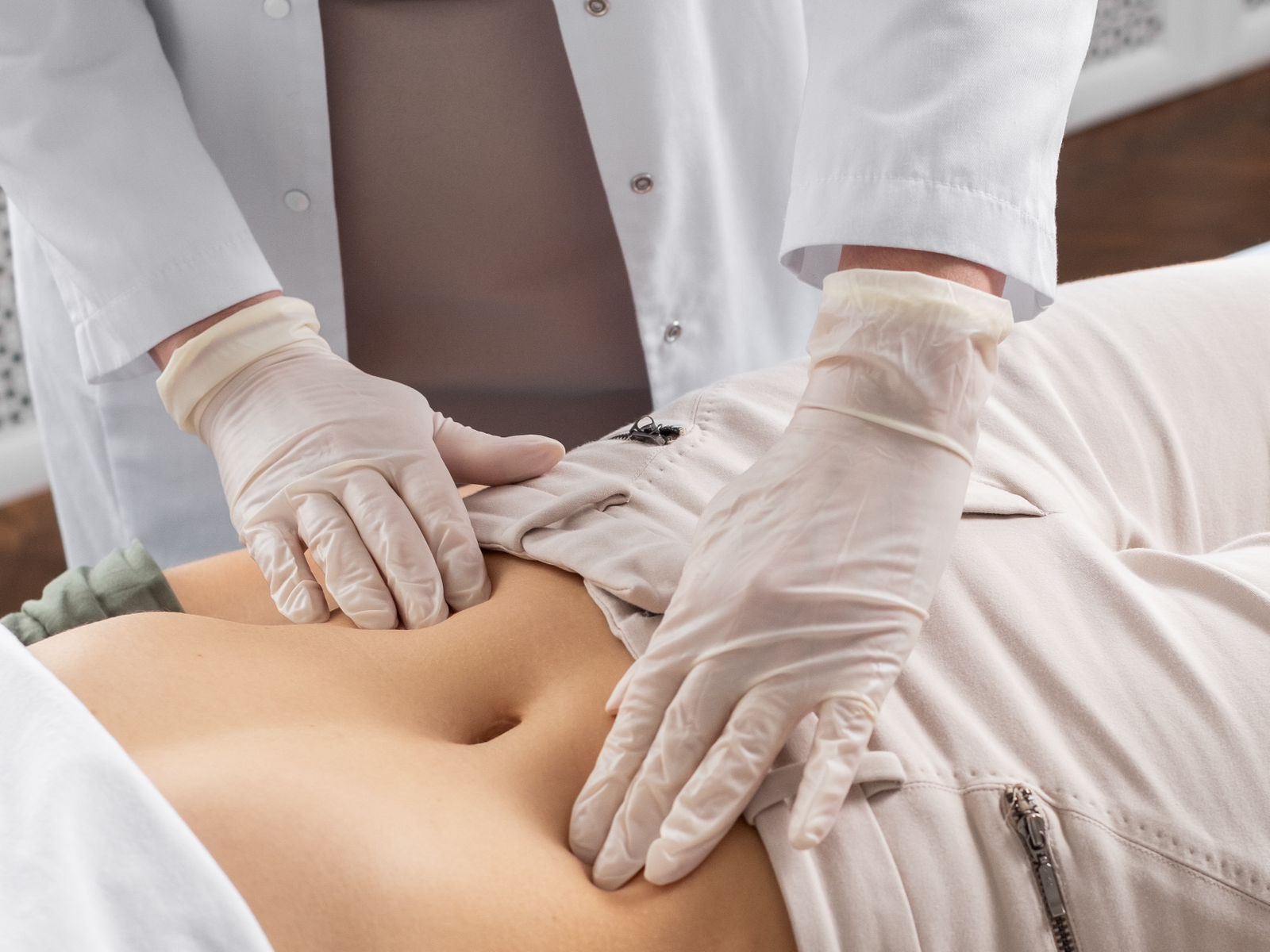 Médico apalpando a barriga