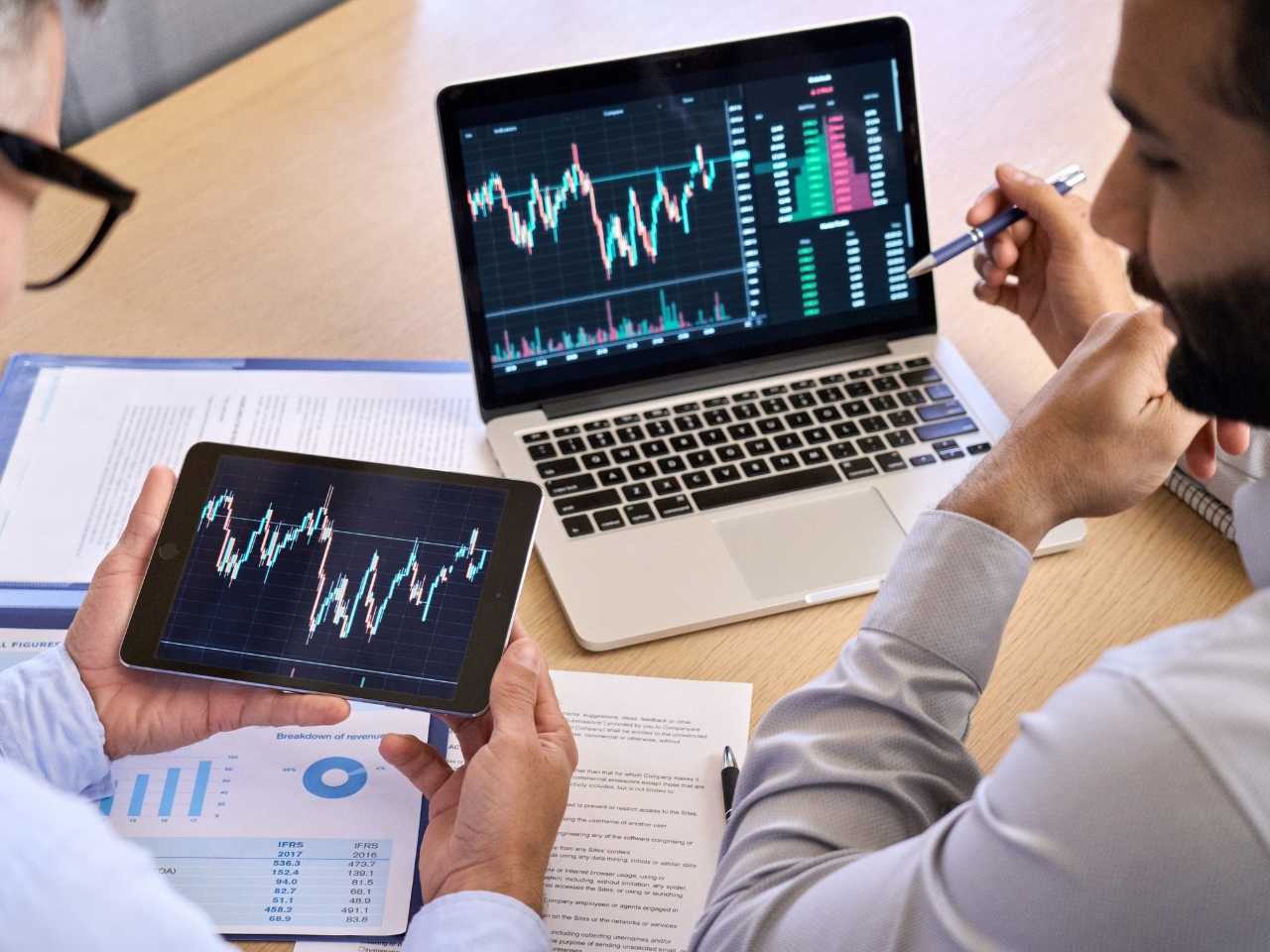 Dois homens olhando os gráficos do mercado