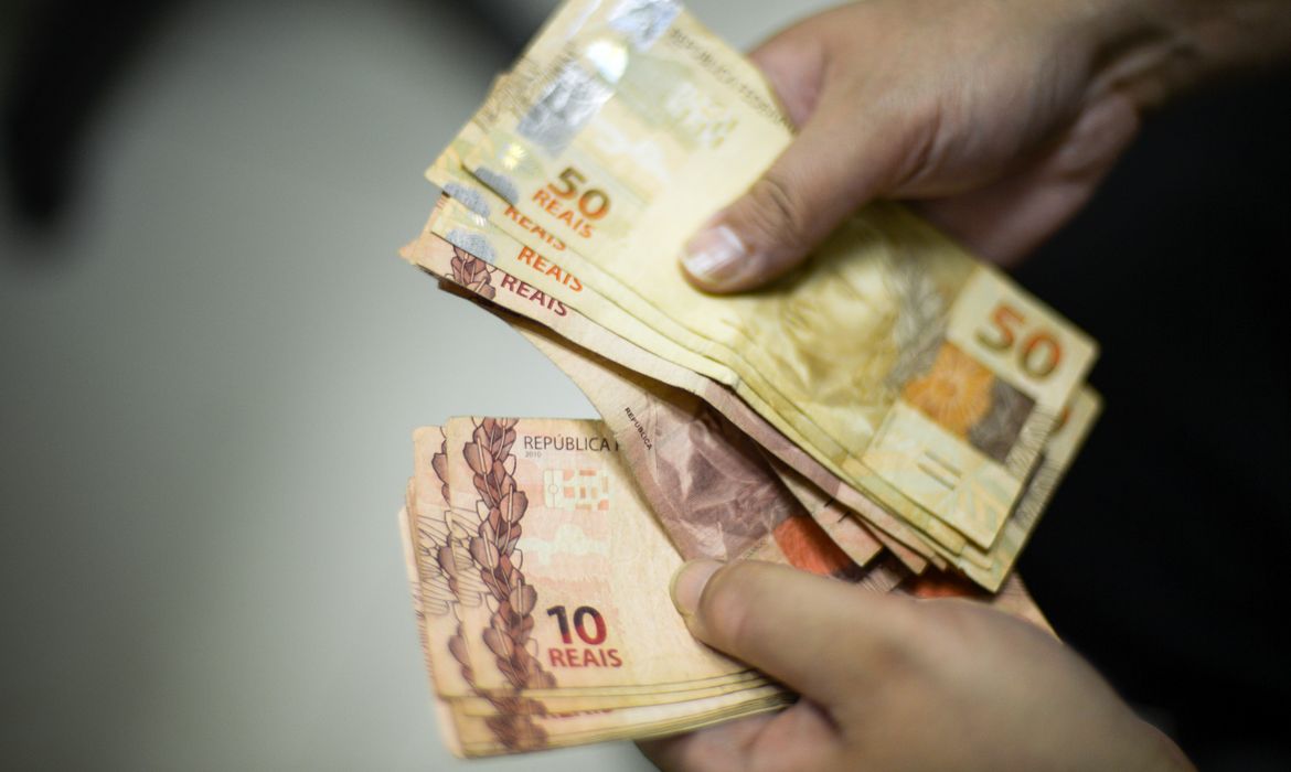 Notas de 10 e 50 reais na mã