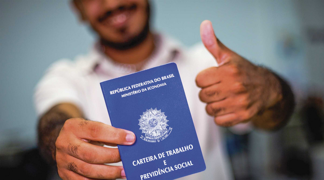 Jovem mostrrando a carteira de trabalho