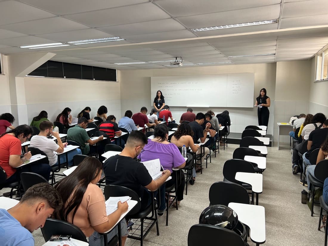 Alunos sentados na sala de aula com o professora