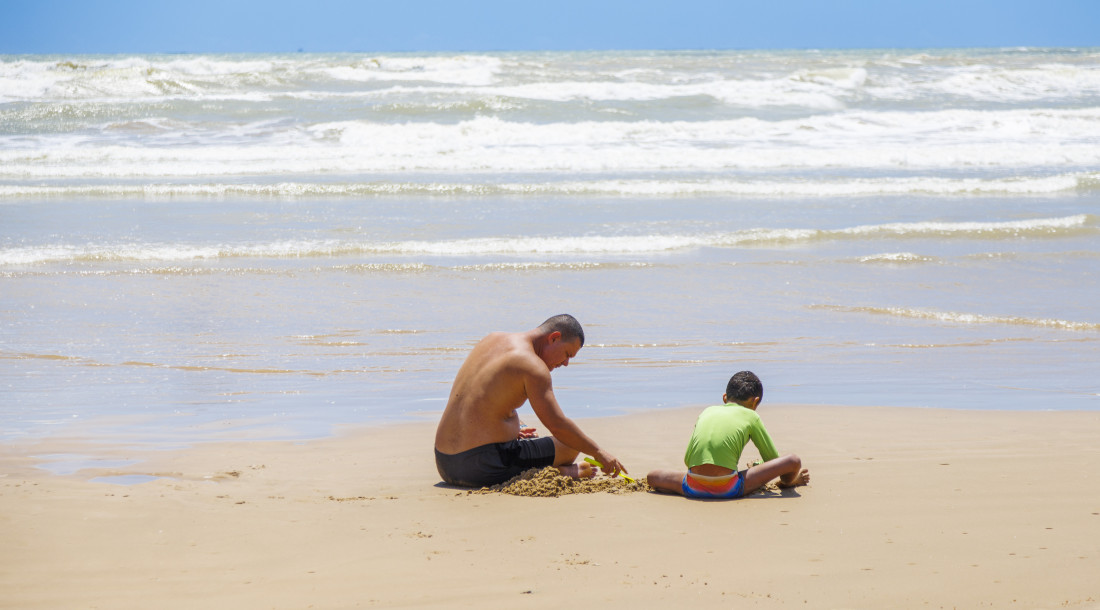 Pai e filho brincando na praia