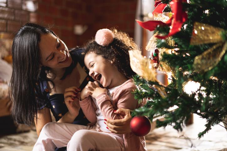 Mãe e filha brincando na árvore de Natal