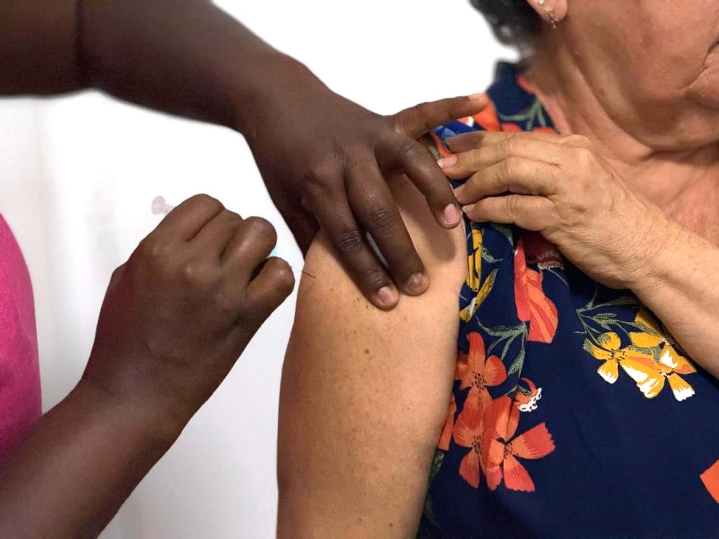 Mulher tomando vacina contra a influenza 