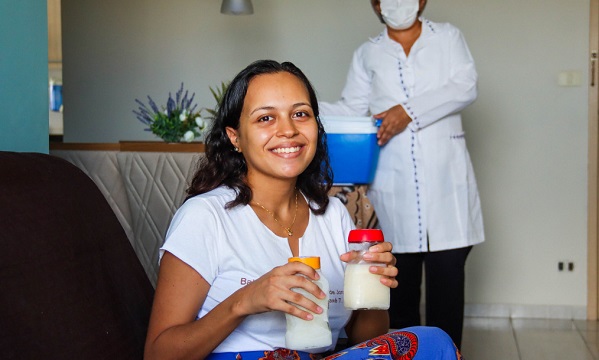 Mulher segurando 2 mamadeiras com leite materno