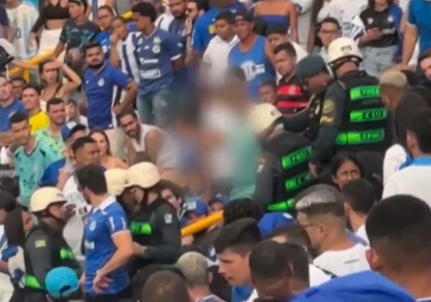 Torcedor com a PM na arquibancada do estádio