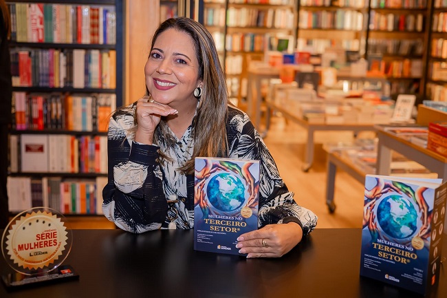 Ulla Ribeiro sentada com o livro