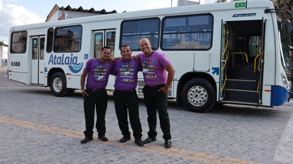 3 motoristas na frente de um ônibus