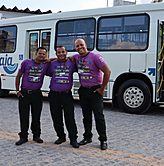 3 motoristas na frente de um ônibus